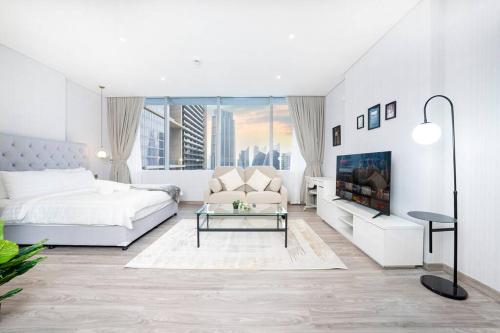 Sky Gardens - Luxury Studio in Central DIFC في دبي: غرفة نوم بيضاء مع سرير ومدفأة