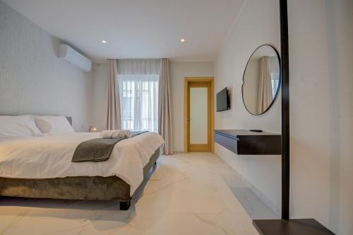 a bedroom with a bed and a mirror and a sink at Mayfair by Premier Suites MT in Is-Swieqi