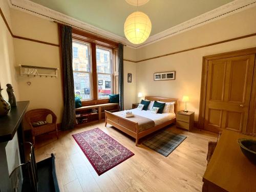 a bedroom with a bed and a large window at Beautiful Spacious Ground Floor Newington flat in Edinburgh