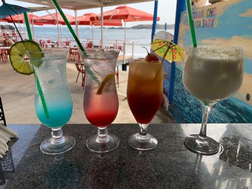 a group of four drinks sitting on a table at Suite Big Lanche in Praia Baixo