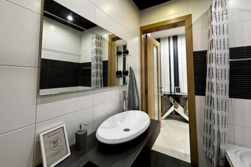 ein Badezimmer mit einem weißen Waschbecken und einem Spiegel in der Unterkunft Salina Maisonette - Pool access in Naxxar
