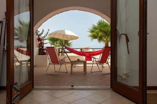 uma porta aberta para um pátio com cadeiras e um guarda-sol em Ca Bonita em Sal Rei