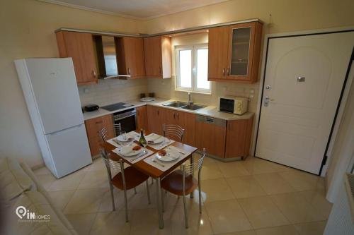 a kitchen with a table and chairs and a white refrigerator at 'On The Wave' With Amazing View in Faraí