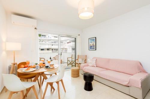 un salon avec un canapé rose et une table dans l'établissement Cannes Victoria YourHostHelper, à Cannes