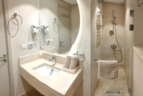 a bathroom with a sink and a mirror and a shower at Mangroovy Gouna 1 BR apartment in Hurghada