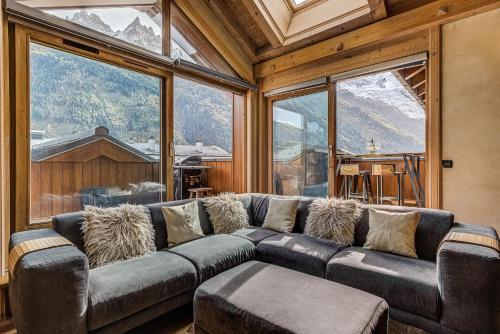 シャモニー・モンブランにあるAPARTMENT LONGVIEW - Alpes Travel - Central Chamonix - Sleeps 8の大きな窓のある客室で、大きなソファが備わります。