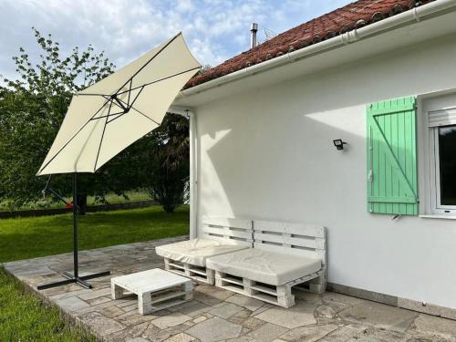 um banco e um guarda-chuva ao lado de um edifício em Villa Simpatía em Merza
