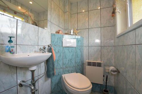 a bathroom with a toilet and a sink at Ferienhaus-Hellmich in Scheibe-Alsbach