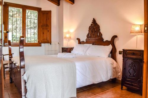 a bedroom with a large bed with white sheets at La Cabanya de la Rovira in Joanetes