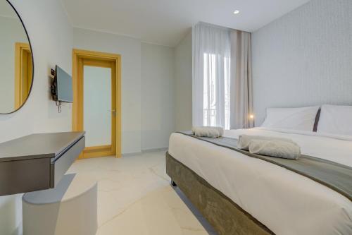 a bedroom with a bed and a desk and a television at Mayfair by Premier Suites MT in Is-Swieqi