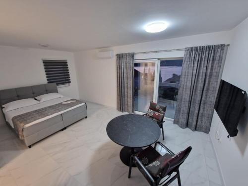 特羅吉爾的住宿－Apartments Filipo，卧室配有一张床和一张桌子及椅子
