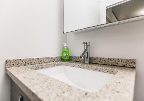 a bathroom sink with a soap bottle on a counter at Stunning 1BD 1BA At UES in New York