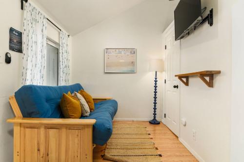 a living room with a blue couch and a television at Sea Haven Motel Unit 2. in Rockaway Beach