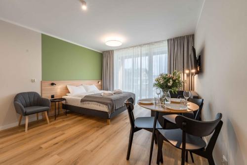 a hotel room with a bed and a table and chairs at Apartament Laguna Beskidów 64 przy Jeziorze Żywieckim - Dream Apart in Zarzecze