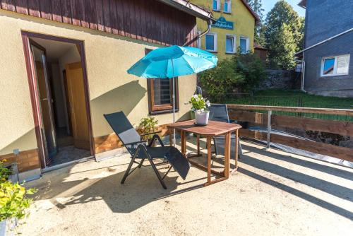a table and a chair and an umbrella on a patio at Im alten Kino in Fehrenbach