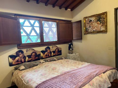 a bedroom with a bed with pictures on the wall at Il Fiorino di Badia in Badia A Passignano