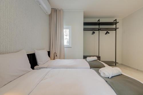 two beds in a hotel room with white sheets at Mayfair by Premier Suites MT in Is-Swieqi