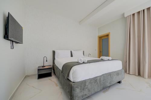 a bedroom with a large bed and a television at Mayfair by Premier Suites MT in Is-Swieqi