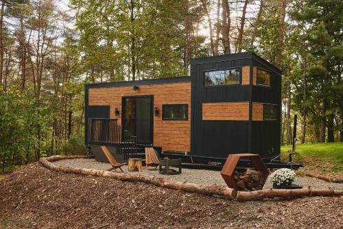 a tiny house in the woods with chairs and trees at Sowilo All-inclusive Resort in Greenwich