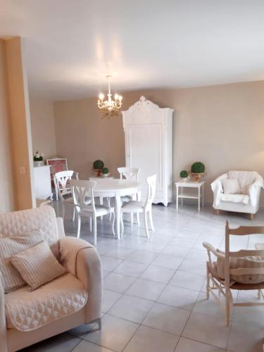 un salon avec une table et des chaises blanches dans l'établissement Le Médicis - Centre village calme, à Bessan