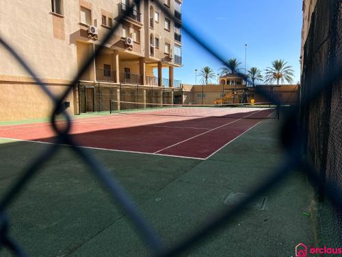 un court de tennis en face d'un bâtiment dans l'établissement Lindo al Mar con Piscina/Tenis, à Benicàssim