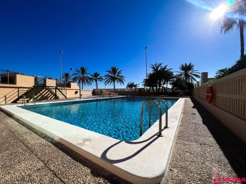 una piscina con palmeras en el fondo en Lindo al Mar con Piscina/Tenis, en Benicàssim