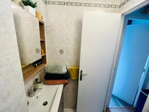 La salle de bains est pourvue d'un lavabo et d'une porte ouverte. dans l'établissement Ornella's flat !, à Charenton-le-Pont