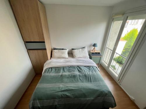 - une chambre avec un lit et une grande fenêtre dans l'établissement Ornella's flat !, à Charenton-le-Pont