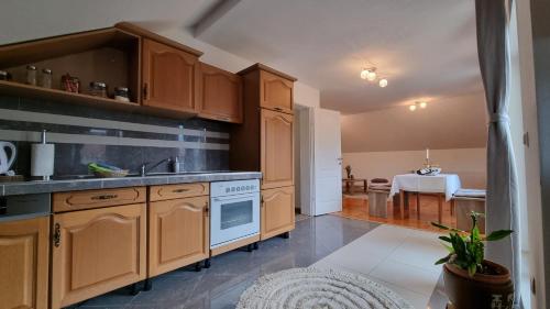 a large kitchen with wooden cabinets and a table at Apartman Jugi 