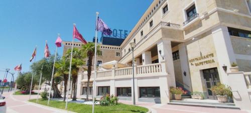 a building with flags in front of it at Hotel Conde Ansúrez in Valladolid