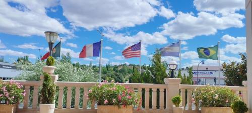 a bunch of flags on a fence with flowers at Hotel Conde Ansúrez in Valladolid