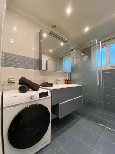 a washing machine in a bathroom with a shower at Villa Miramar Near Disneyland Paris in Annet-sur-Marne