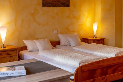 2 camas individuales en una habitación con 2 lámparas en Ferienpark Auf dem Simpel - Vierbettzimmer 3, en Soltau