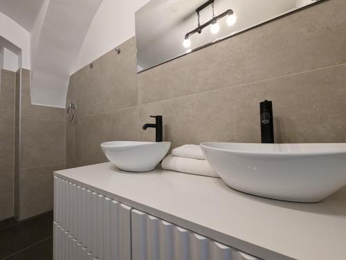 - une salle de bains avec 2 lavabos blancs sur un comptoir dans l'établissement Fantabulous Upper-Town Condo, à Zagreb