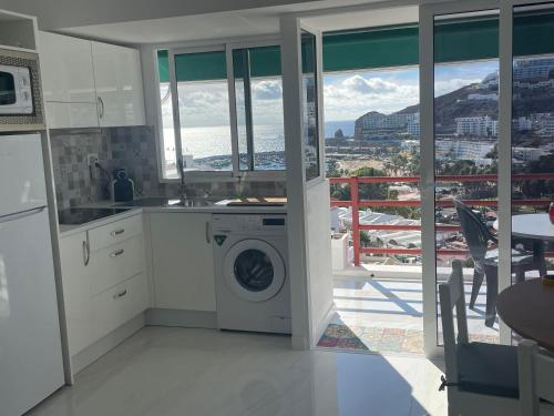 kuchnia z pralką i balkonem w obiekcie El Libre Playa Puerto Rico w mieście Puerto Rico de Gran Canaria