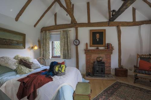 a bedroom with two beds and a brick fireplace at Finest Retreats - The Ratcatchers Cottage 