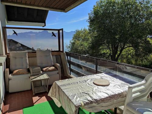 a patio with a table and chairs on a balcony at Petit paradis cocooning avec balcon à Torgon in Vionnaz