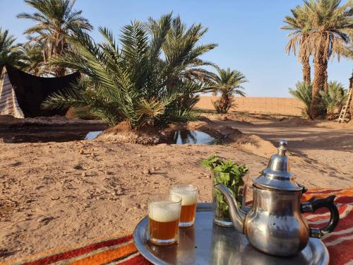- un plateau avec deux verres de bière et une bouilloire dans l'établissement ATFIL CAMP, à M'Hamid El Ghizlane