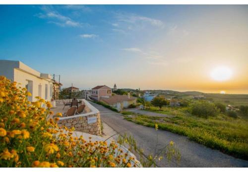 a road leading to a house with the sunset in the background at Iliovasilema Holiday House in Volimes
