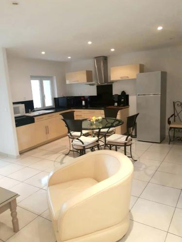 un salon avec un canapé et une table et une cuisine dans l'établissement L'Olivier - Centre village - Au calme, à Bessan
