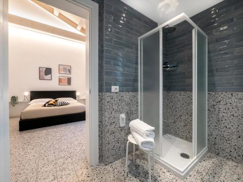 a bathroom with a shower and a bed at Zuara9Room Rimini in Rimini