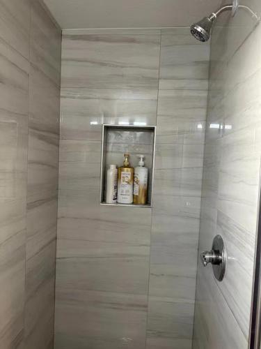 een badkamer met een douche en alcoholflessen op een plank bij 20% Off Studio in Cebu IT Park w/ Great City View in Manilla