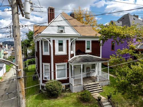a house with a porch and a purple house at Parkside Paradise Elegant Victorian Home Just Steps from the Park in Homestead