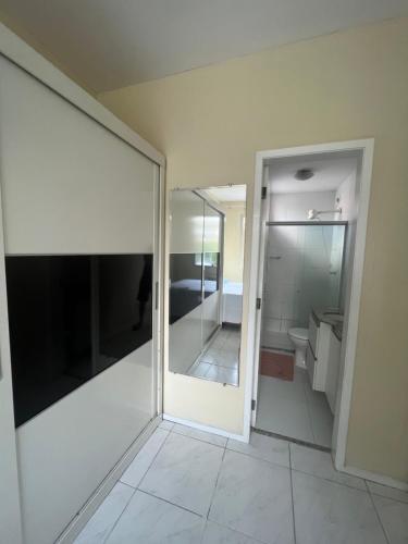 baño con puerta corredera de cristal y espejo en Apartamento em condomínio Belém, en Belém