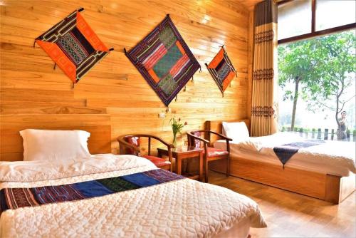 a bedroom with two beds in a room with wooden walls at Thanh Ha Hotel in Chơ Mơi