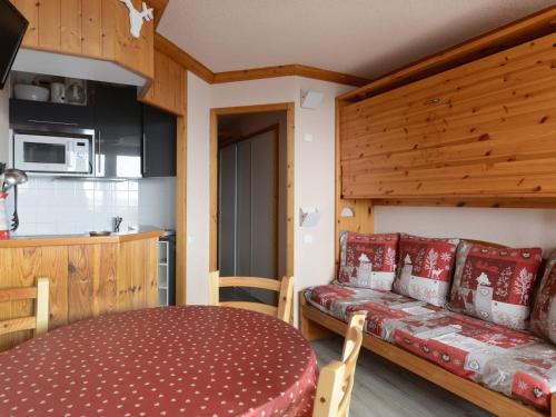 une chambre avec une table et un canapé dans une cuisine dans l'établissement Studio confortable au pied des pistes, balcon, animaux admis - FR-1-181-2562, à Aime La Plagne