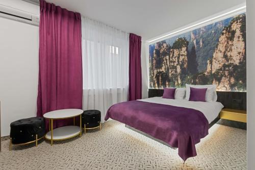 a bedroom with a large bed and purple curtains at Fit Residence in Cluj-Napoca
