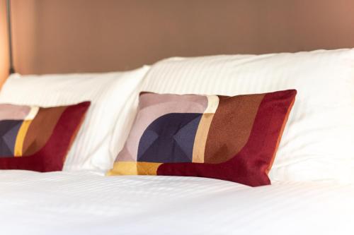 two pillows sitting on top of a white bed at Casa Leopoldo in Pisa