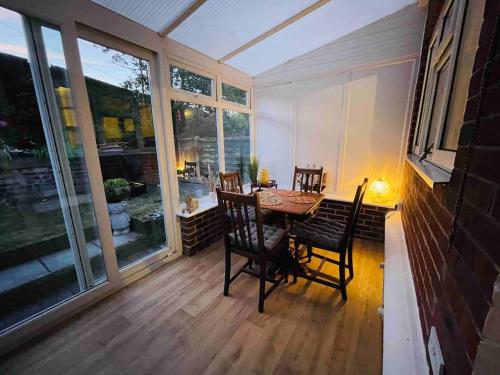 a dining room with a table and chairs on a porch at Cosy Stay in the Heart of Dover in Kent