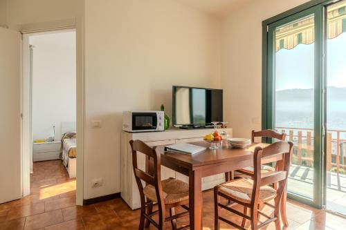 une salle à manger avec une table, des chaises et une télévision dans l'établissement Casa Dolce Casa, à Sarnico